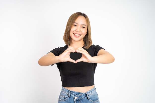 Woman smiling in heart shape with fingers on isolated