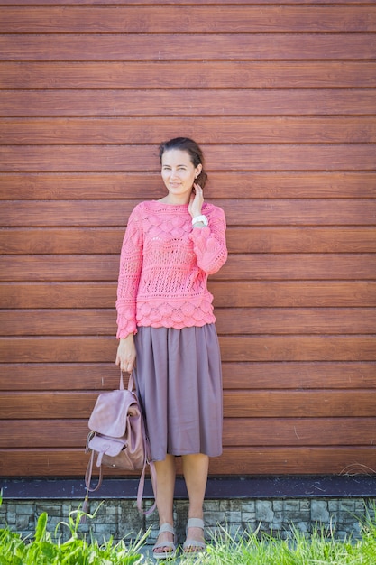 Woman smiling and holding a pink backpack