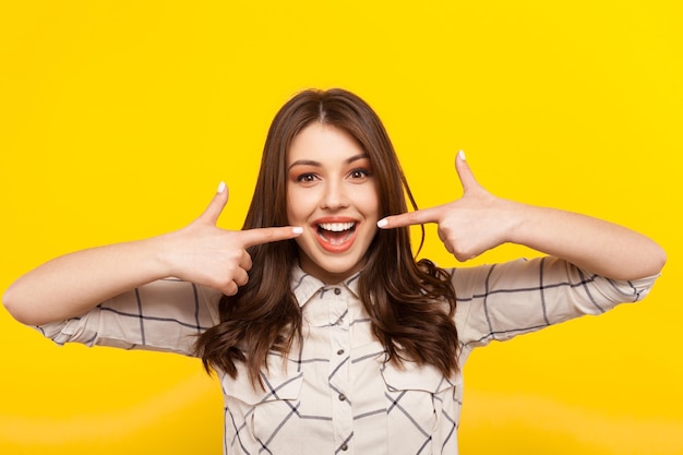 Woman smiling and pointing at mouth