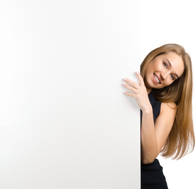 Donna che sorride mostrando il tabellone per le affissioni in bianco bianco del segno