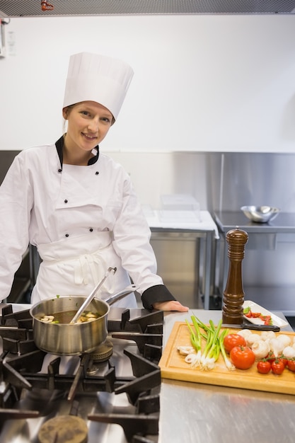 Woman smiling while cooking soup