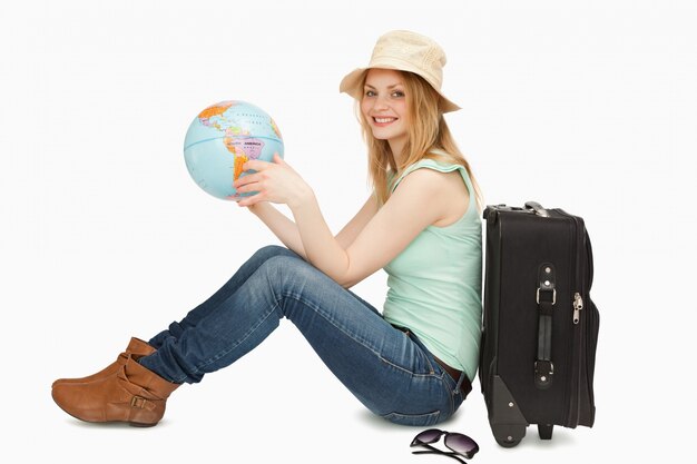 Photo woman smiling while holding a world globe