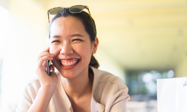 woman smiling while talking by smartphone in freedom time