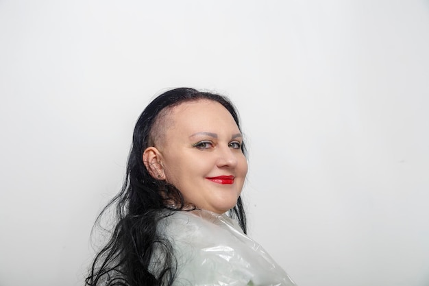 Woman smiling with half shaved head in barber chair horizontal\
photo