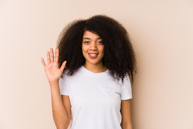 Woman smiling with hand raised