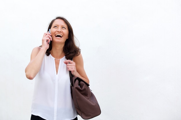 Woman smiling with mobile phone and bag