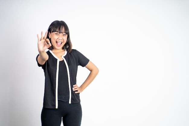 Woman smiling with okay hand gesture on isolated background