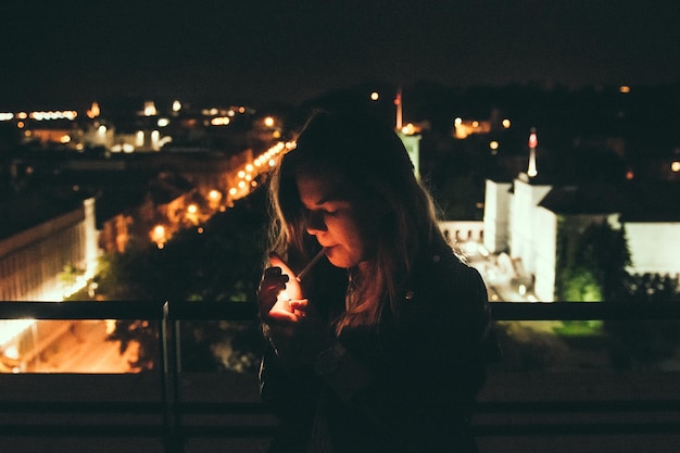 Photo woman smoking on balcony at night