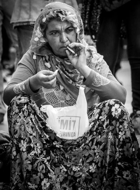 Foto donna che fuma una sigaretta all'aperto