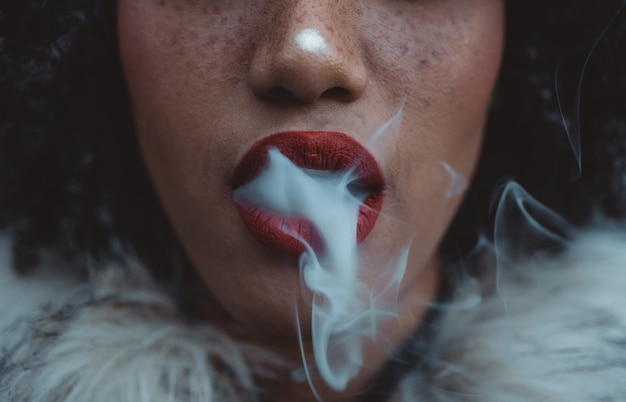 Woman smoking, close up on smoke and mouth