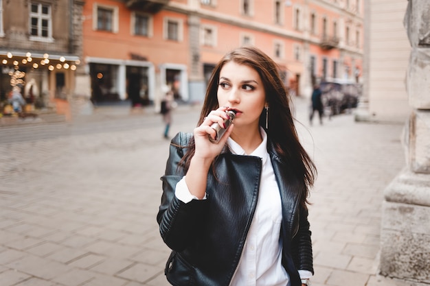 Женщина курит электронную сигарету