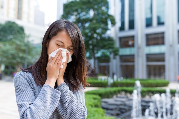 woman sneeze at outdoor