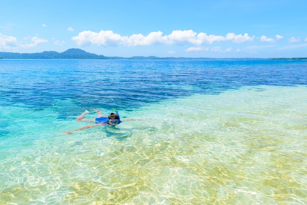 Woman snorkeling in caribbean sea, turquoise blue water, tropical island