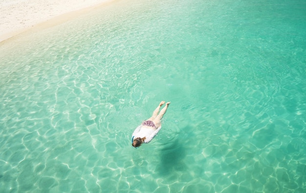 Woman snorkling and relaxing crystal clear and turquoise sea water of the tropical sea