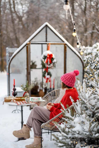 Woman at snowy backyard on winter holidays