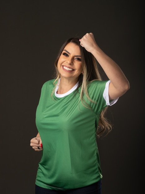 Woman soccer fan cheering for her favorite club and team world cup green background