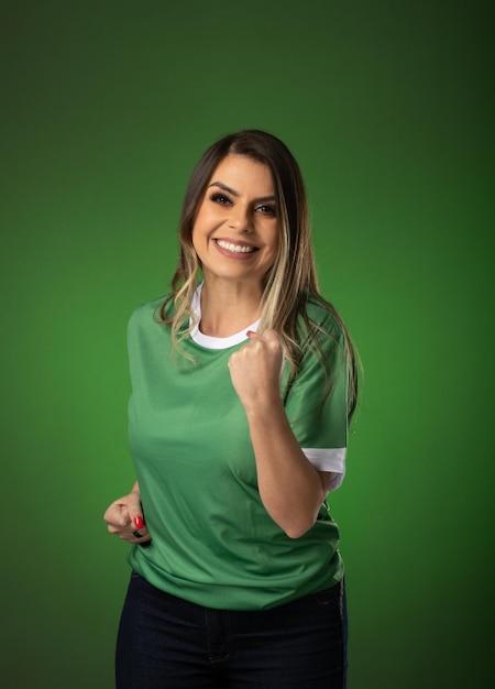 Woman soccer fan cheering for her favorite club and team world cup green background