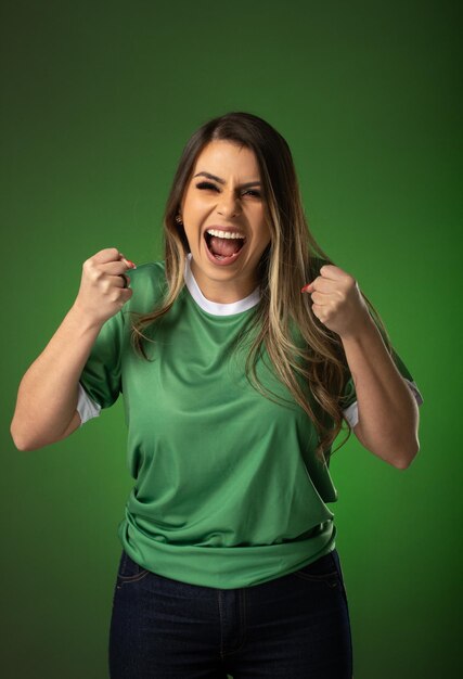 Woman soccer fan cheering for her favorite club and team world cup green background