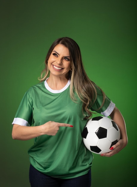 Футбольный фанат женщина болеет за свой любимый клуб и командный кубок мира на зеленом фоне