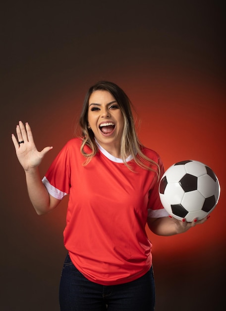 Woman soccer fan cheering for her favorite club and team world cup red background