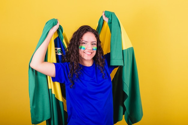 Woman soccer fan fan of Brazil world cup dancing with flag on her back celebrating victory