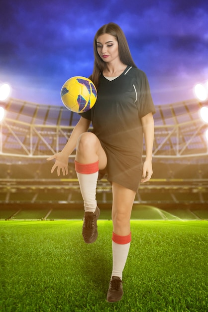 Woman soccer player with soccer ball at stadium