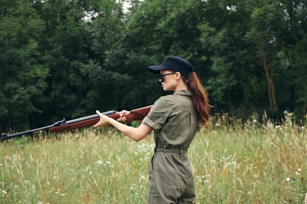 Woman soldier side view with arms in sunglasses green overalls green