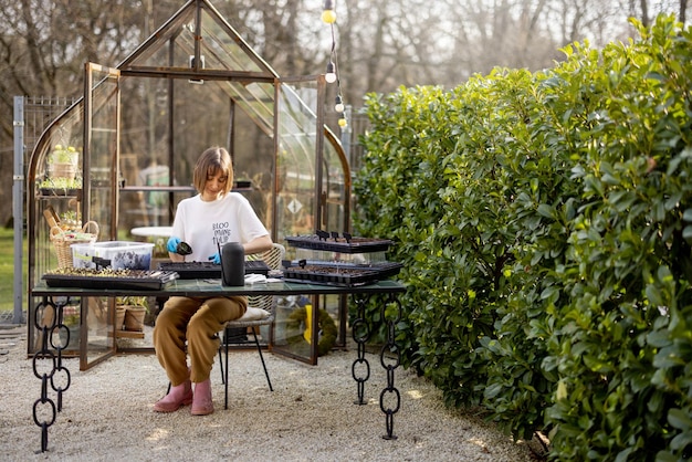 Woman sowing flower seeds at backyard