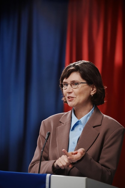 Woman speaking in microphone by platform