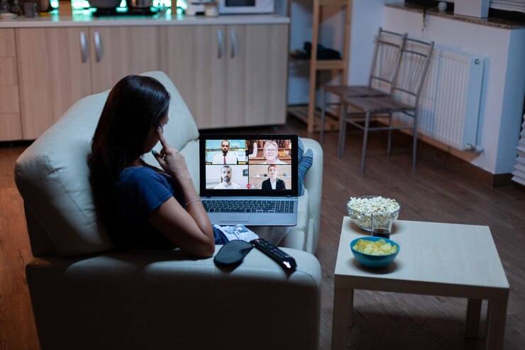Photo woman speaking with colleagues on webcam lying on sofa at home