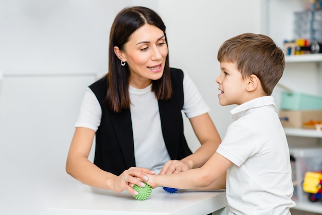 A woman speech therapist deals with the child and teaches him the correct pronunciation and competent speech.