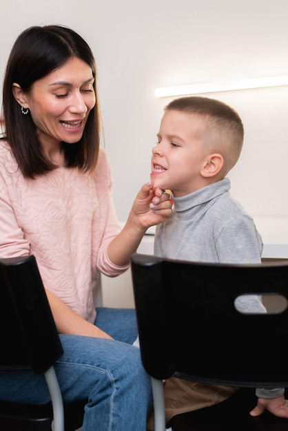 A woman speech therapist deals with the child and teaches him the correct pronunciation and competent speech.