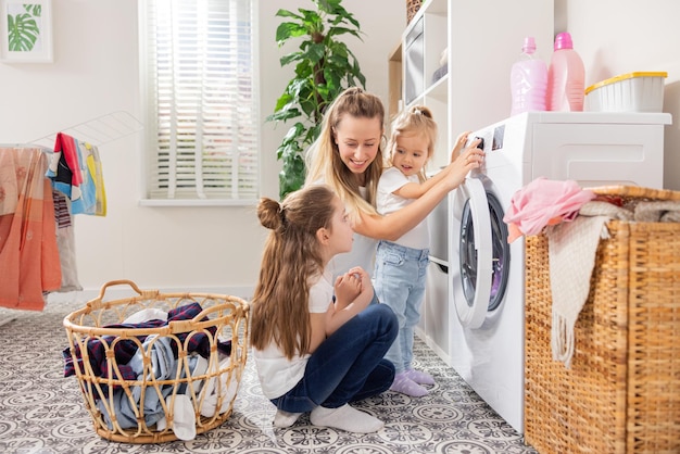 woman spends time with young children in laundry room bathroom performs household duties