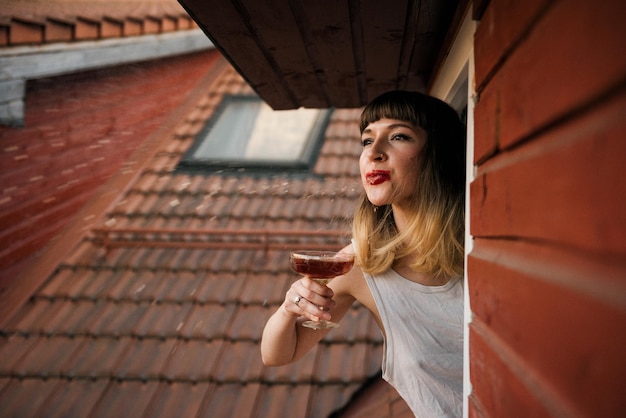 Фото Женщина плюет на выпивку в окно.