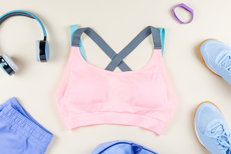 Photo woman sport clothes, sneakers, headphones and fitness tracker on neutral