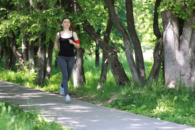 Lo sport della donna corre nel parco all'aperto