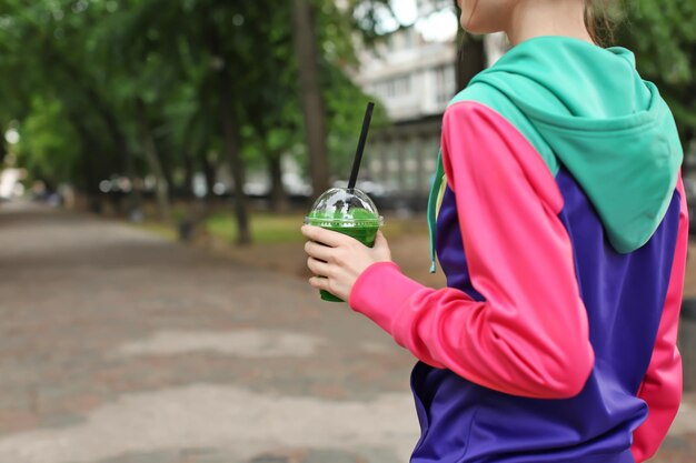 Premium Photo | Woman in sport suit walking outdoors with green smoothie