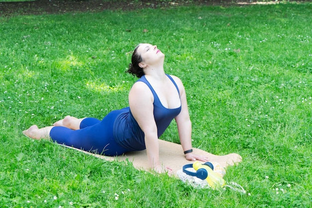 Woman and sports exercise for stretching and weight loss in the fresh air happy curvy 40s woman doing workout stretch routine outdoor at city park