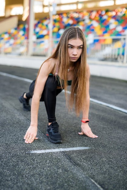 スタジアムで朝のランニングをしているスポーツウェアの女性