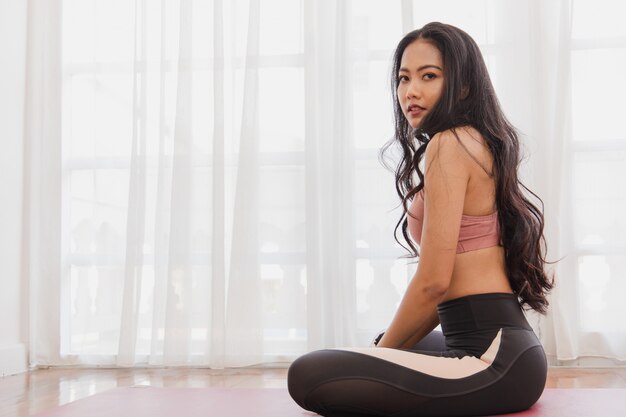 Woman in sportswear doing yoga at home