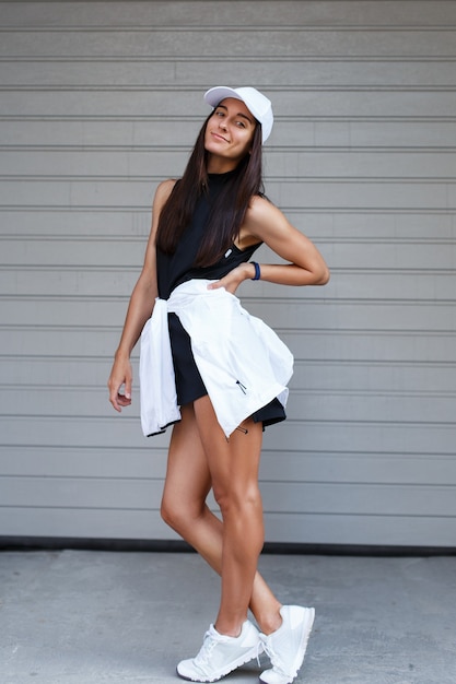 Photo woman in sportswear on gray garage door.