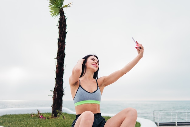 Photo woman in sportswear holding a smartphone