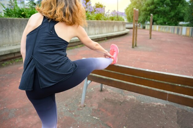 Foto la donna in abiti sportivi si allunga dopo aver fatto sport