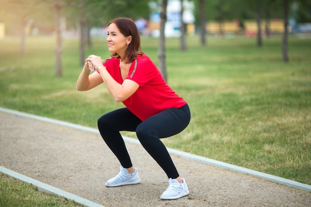 Woman in sportswear stretching before jogging in the park