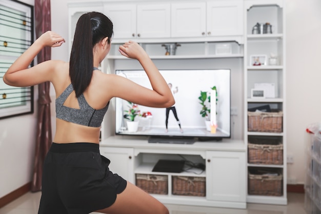 Woman in sportswear working out at home