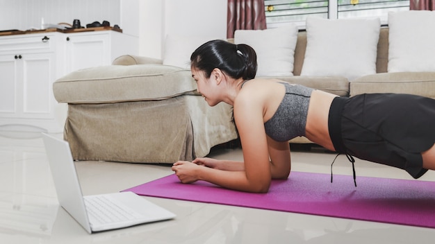 Woman in sportswear working out at home