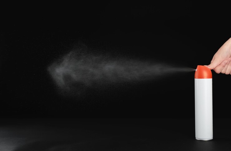 Photo 黒の背景のクローズ アップに芳香剤を噴霧する女性