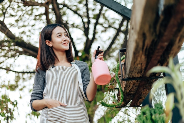 写真 植物に水をスプレーする女性