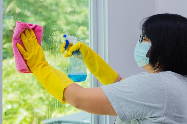 Woman spraying and wiping glass