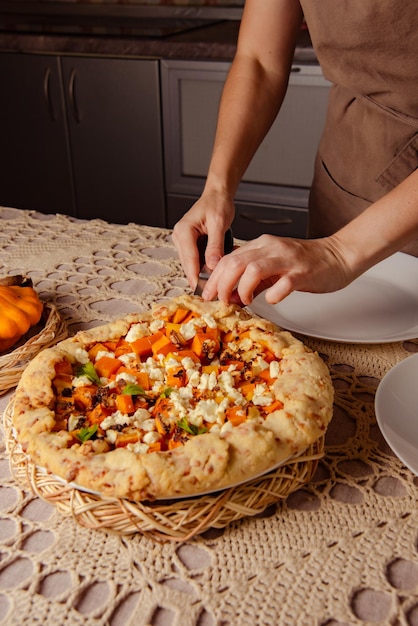 Photo woman spreads freshly baked pumpkin open pie on plates in cozy home savory pie